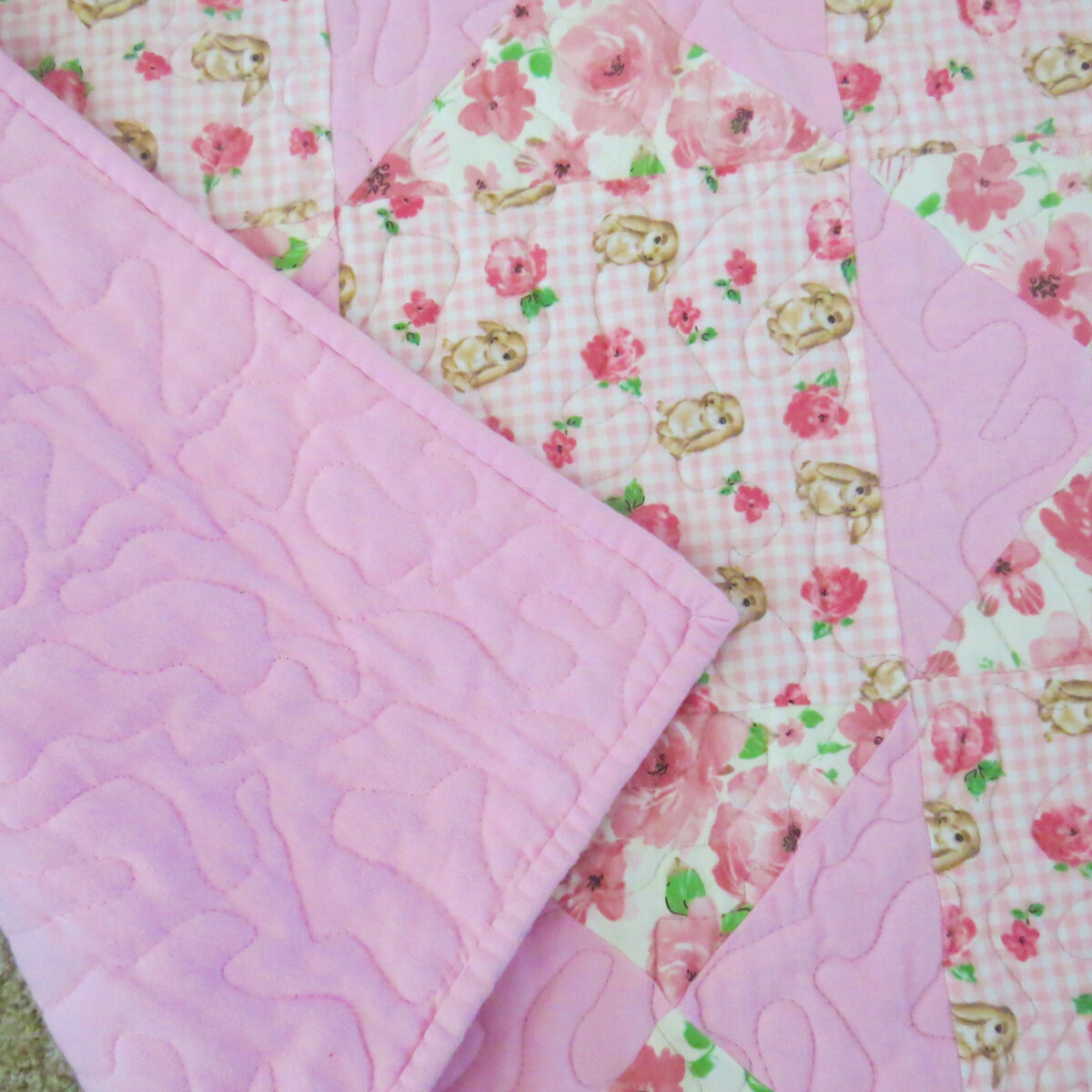 Bunny Trails Baby Quilt wuth pink backing visible