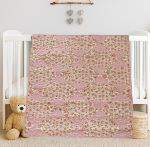 Bunny Trails Baby Quilt draped on white crib with bear