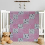 Bunny Frloic Baby Quilt draped on white crib with bear