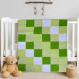 Bunny Cuddes in Green Baby Quilt draped on white crib with bear